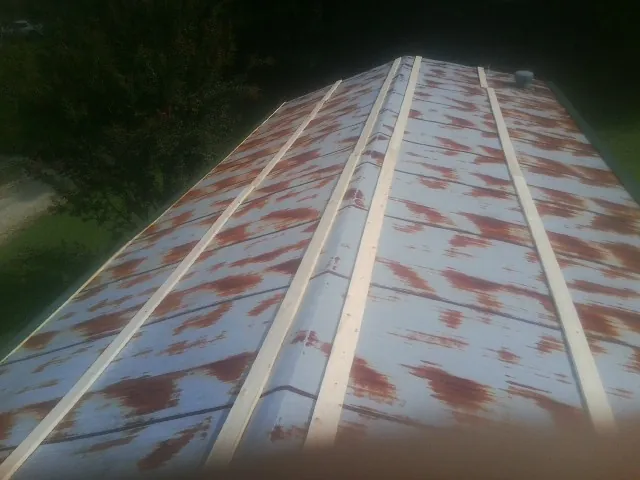 Rusted metal roof panels with new wood purlins before replacement — Storm Damage Roof Repair in Water View by Roofing Brothers
