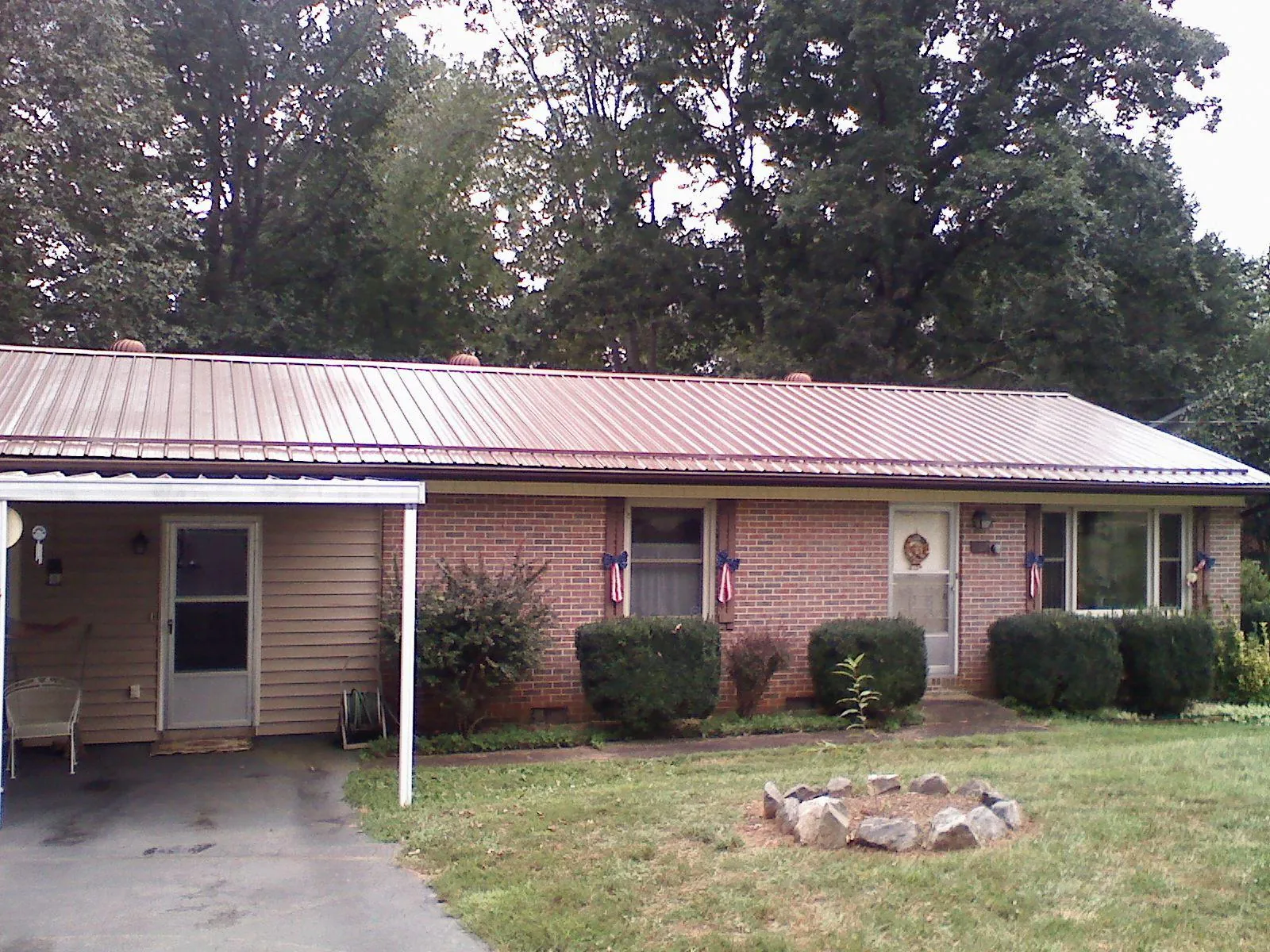 Bronze metal roof and carport on a brick ranch home — Roof Repair work by our crew in Water View
