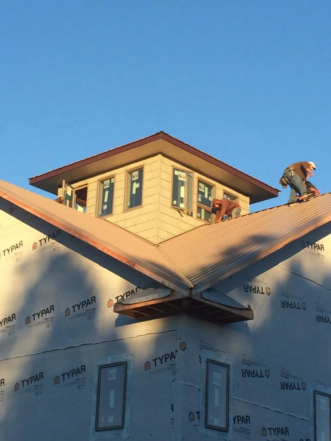 Roofers working around a rooftop cupola on a new metal roof at sunset — Roof Waterproofing in Water View by Roofing Brothers